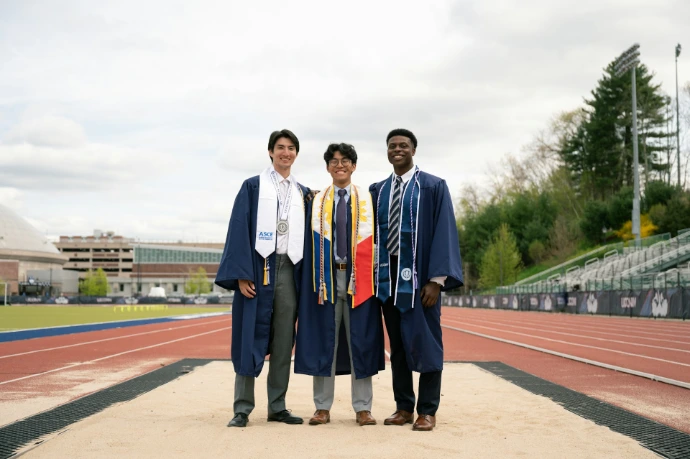 a group of three men standing next to each other on a track